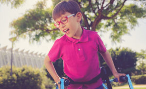 A child with CP (a condition often included in birth injury statistics) uses a walker in a park.
