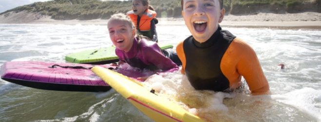 Three kids surf in the ocean