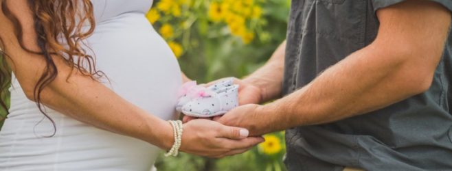 a pregnant woman and a man hold hands