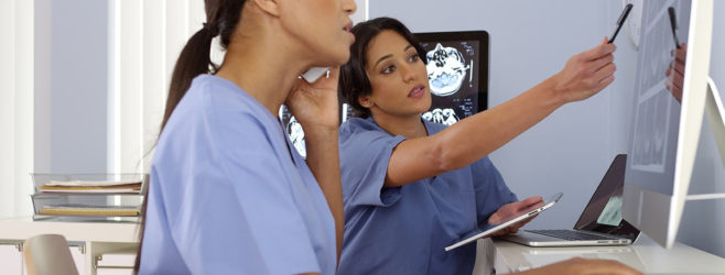 Two women doctors looking at x-rays.