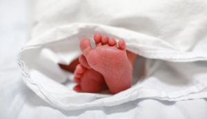 A newborn's feet sticking out of a blanket.