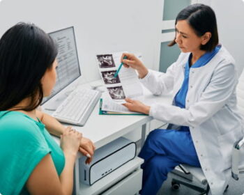 An obstetrician shows a patient ultrasound images of her unborn baby.