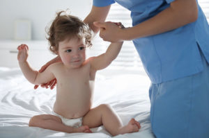 An Erb's palsy doctor checks a child's arms.