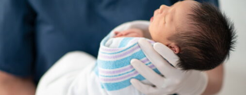 Medical staff holding healthy baby