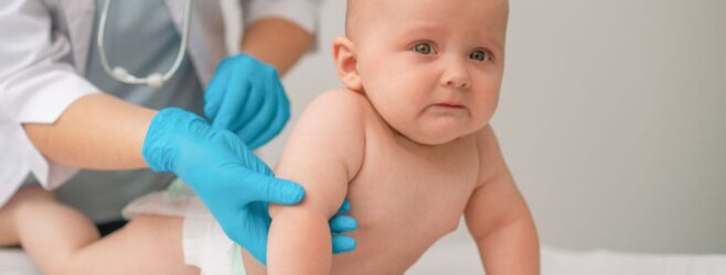 A doctor examines a baby’s arm for signs of brachial plexus nerve damage.
