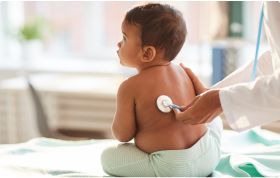 A medical professional uses a stethoscope to examine a baby's back during a check-up.
