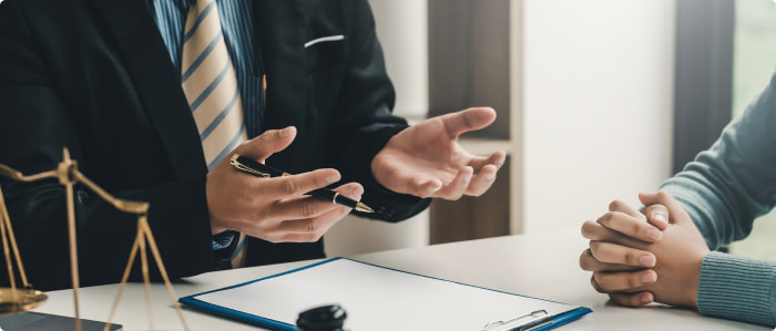 A lawyer in a suit sitting at a desk explains to a client who can sue for cerebral palsy.