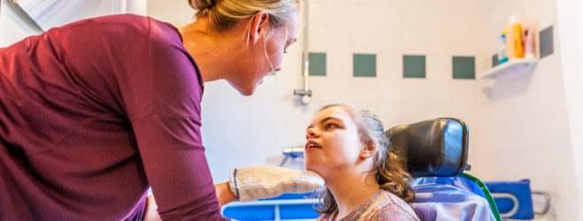 a nurse helps a girl with cerebral palsy