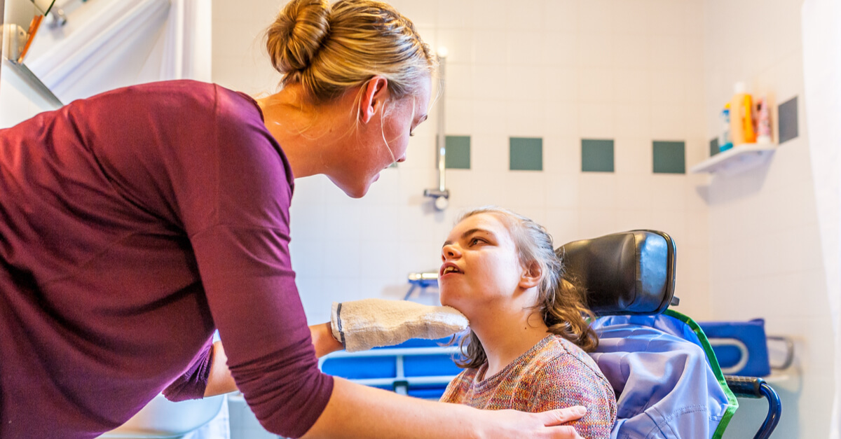 A medical professional examines the face and neck of a child with special needs.