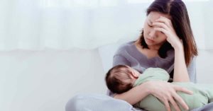 tired mother holding baby