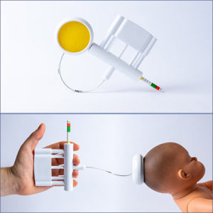 A vacuum extraction device with a suction cup attached to the top of a mannequin newborn's head.